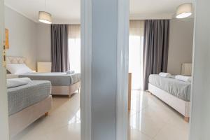 a bedroom with two beds and a mirror at M&P Apartment by RentalsPro - Nea Moudania Halkidiki in Nea Moudania +10 photos