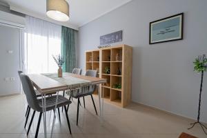 a dining room with a wooden table and chairs at M&P Apartment by RentalsPro - Nea Moudania Halkidiki in Nea Moudania