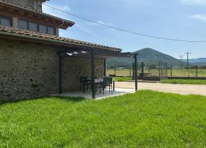 a table and chairs under a pavilion outside of a house at Can Iglèsies, Vall d'en Bas in Mallol