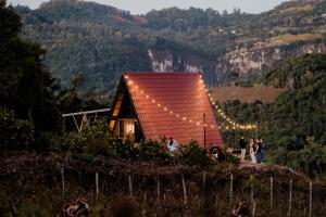 a group of people standing in front of a house with lights at Cabanas CAVITA- Vale dos Vinhedos in Monte Belo