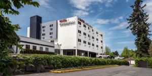 een wit gebouw met een auto ervoor geparkeerd bij Hotel International in Lynnwood