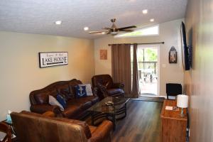 a living room with leather furniture and a ceiling fan at Keepin' it REEL in Guntersville