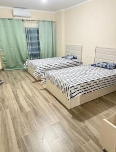 deux lits dans une chambre avec parquet dans l'établissement Downtown new Alamain apartments near Rixos El Alamain, à El Alamein