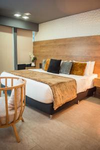 a bedroom with a large bed and a chair at Mantra Hotel Boutique in Santa Marta