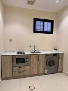 eine Küche mit Spüle und Waschmaschine in der Unterkunft شقق الأول للشقق المخدومة in Quai