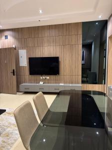ein Wohnzimmer mit Glastisch und Fernseher in der Unterkunft شقق الأول للشقق المخدومة in Quai