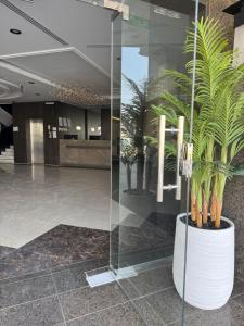 eine Lobby mit einem großen Pflanzer mit Pflanzen darin in der Unterkunft شقق الأول للشقق المخدومة in Quai