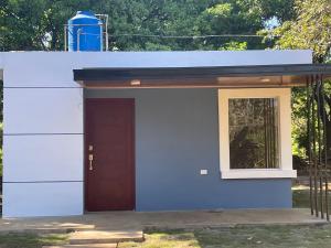 a blue garage with a door and a window at Quinta el Refugio in Masaya +3 photos