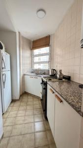 une cuisine avec un évier et une cuisinière four supérieur dans l'établissement Ayacucho loft, à Córdoba