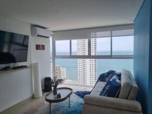 a living room with a couch and a table and a large window at apto navy 6 tripulantes in Cartagena de Indias