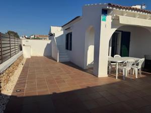 a patio with a table and chairs on a house at Es Canto in Cala Blanca