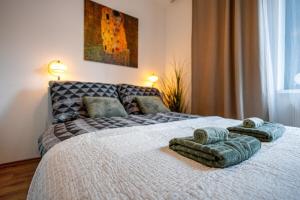 ブラチスラヴァにあるADM Premium Center Apartmentのタオルが敷かれたベッドのある寝室