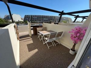 a patio with a table and chairs on a balcony at La suite des charmes - village naturiste - port nature 2 coursives in Cap d'Agde +10 photos