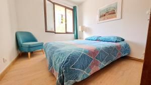 a bedroom with a bed and a blue chair at Mazet en provence pour 4, piscine chauffée privée, jardin clos privé, barbecue, chiens admis in Sainte-Jalle +16 photos