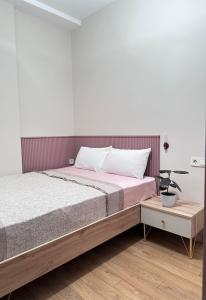 a bedroom with a large bed and a table at Home Side Apartment in Batumi