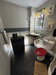 a bathroom with a red toilet and a sink at Madrid Loft duplex in Madrid