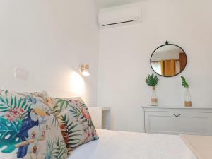a bedroom with a bed with a pillow and a mirror at Bungalow Capri Maspalomas in San Bartolomé +33 photos