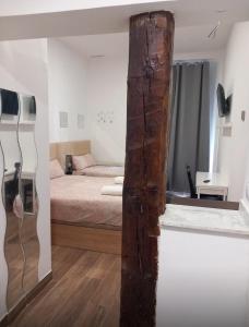 Pokój z łóżkiem i drewnianym słupem w obiekcie Estudio Corazón de Chueca w Madrycie