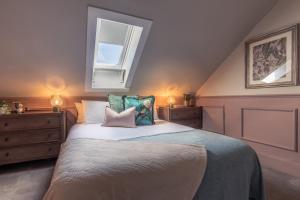 Un dormitorio con una cama con almohadas y una ventana. en The Nessting Place, en Inverness
