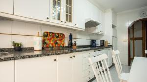 a kitchen with white cabinets and a counter top at Casa Marinera en A Guarda in A Guarda