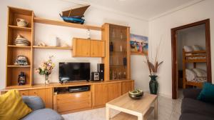 a living room with a tv and wooden cabinets at Casa Marinera en A Guarda in A Guarda