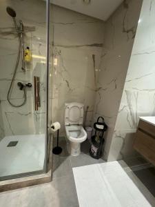 une salle de bain avec toilettes et douche en verre dans l'établissement Luxurious One Bedroom By Rabat Train Station, à Rabat