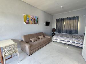 a living room with a couch and a bed at Casa Mineira - Flats novos em Ponta de Mangue - Maragogi in Maragogi +34 photos
