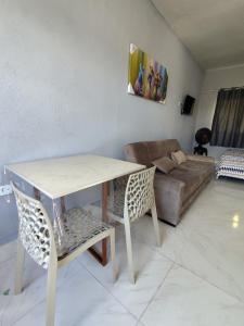 a living room with a table and a couch at Casa Mineira - Flats novos em Ponta de Mangue - Maragogi in Maragogi