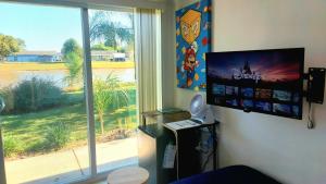 Habitación con ventana grande y monitor de ordenador. en Small Lakeview Suite Near Disney & Universal, en Kissimmee