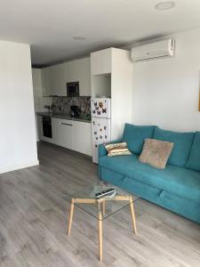 a living room with a blue couch and a table at Lucy lux apartament in Las Palmas de Gran Canaria