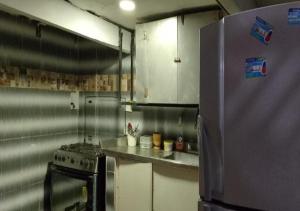 a kitchen with a stove and a stainless steel refrigerator at Hostal #10-33 in Cartagena de Indias