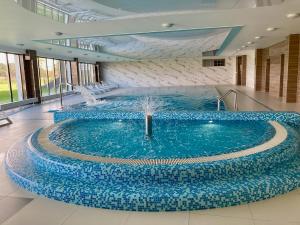 a large pool with a fountain in a building at ParaSOL - Baltic Relax - Pool, Jacuzzi, Sauna in Dziwnów