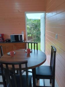 Ein Holztisch und Stühle in einer Küche mit Fenster in der Unterkunft Casa das Palmeiras in Rio Forcação