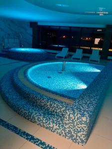 ParaSOL - Baltic Relax - Pool, Jacuzzi, Sauna في جيفنوف: مسبح في مبنى فيه كراسي