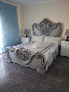 a bedroom with a bed with a large headboard at Appartement avec Vue sur Mer à Praia, Wi-Fi, Navette Aéroport in Praia