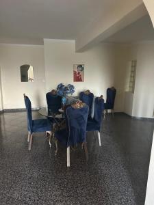 a dining room with a glass table and blue chairs at Appartement avec Vue sur Mer à Praia, Wi-Fi, Navette Aéroport in Praia
