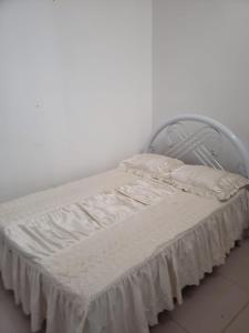 a bed with white sheets and a metal headboard at Appartement avec Vue sur Mer à Praia, Wi-Fi, Navette Aéroport in Praia