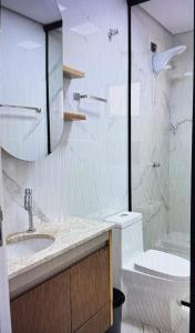 a bathroom with a shower and a sink and a toilet at Apto a 100 metros das piscinas Balneário Piratuba in Água Doce
