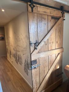 an old barn door in a living room at L’étable d’Auguste in Arreau