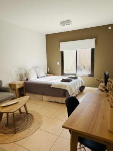 a large bedroom with a bed and a table at Champa Apart Pilar - EXCELENTE UBICACIÓN EN PILAR in Pilar