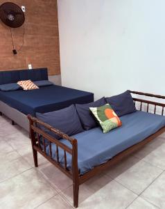 a bed with blue sheets and pillows in a room at Studio Vista Linda 2 - Acesso a Riviera e Centro Kitnet in Bertioga