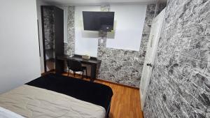 a bedroom with a bed and a tv on a wall at Colisseum Roma - Vive Claro -El cubo movistar campin in Bogotá +24 photos