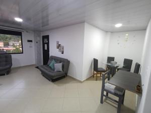 un salon avec un canapé, une table et des chaises dans l'établissement Hospedaje samfer, à Envigado