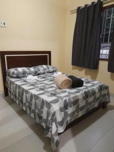 - un lit avec une couette grise et blanche dans l'établissement Curitibanos, à Joinville