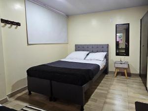 a large bed in a room with a chalkboard on the wall at Roma House N- suite Campin Movistar Ministerios Simón Bolivar in Bogotá