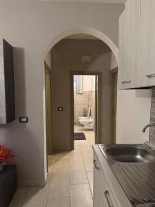 una cucina con lavello e un corridoio con un bagno di Domu Grìsia Apartment Arzachena a Arzachena