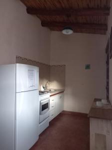a kitchen with a white refrigerator and a sink at Departamentos Complejo Turístico Cruz Mendoza in Tilcara