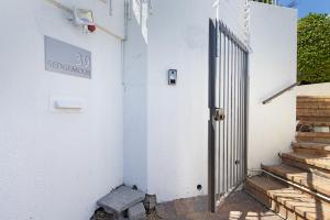 an entrance to a white building with a gate at Camps Bay private room and bathroom in Cape Town