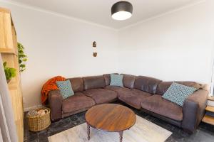a brown couch in a living room with a table at Camps Bay private room and bathroom in Cape Town