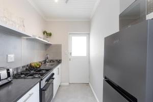 a kitchen with a refrigerator and a stove top oven at Camps Bay private room and bathroom in Cape Town